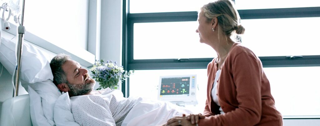 Lady visiting someone in a hospital bed