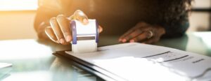 Woman Using Notary Stamp On Official Paper